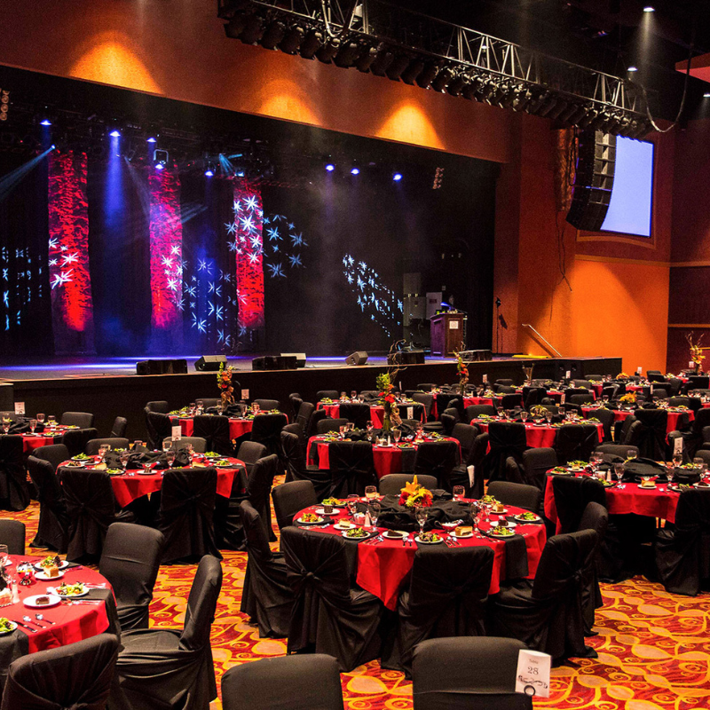 Corporate conference stage with dramatic lighting and banquet setup